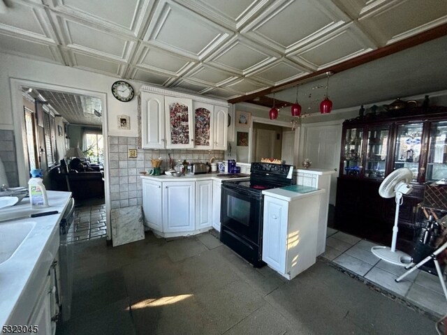 kitchen featuring white cabinetry, black range with electric stovetop, and kitchen peninsula