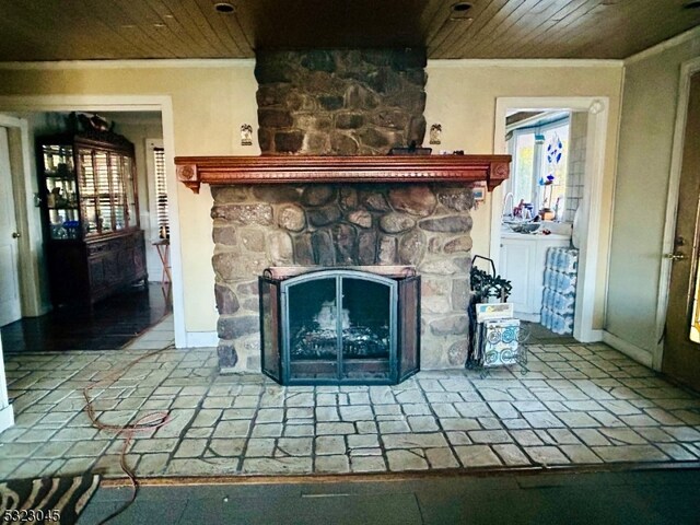 details featuring a stone fireplace, wood ceiling, and crown molding