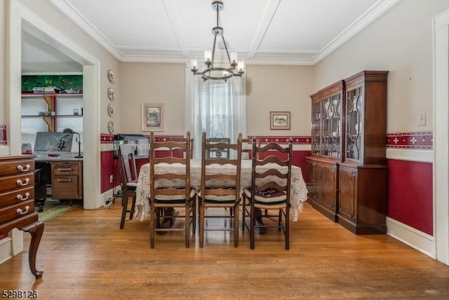 dining room featuring crown molding, light wood-style floors, coffered ceiling, and a chandelier