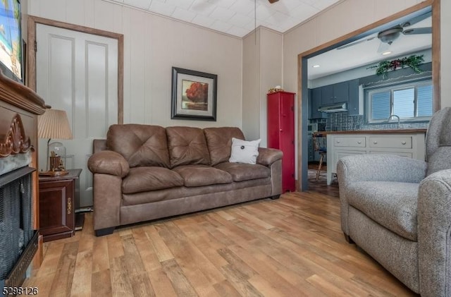 living area featuring light wood-style flooring and a fireplace