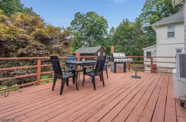 deck featuring an outbuilding, area for grilling, and outdoor dining space