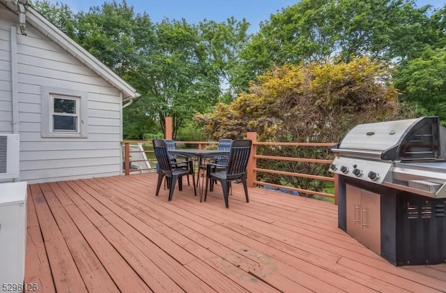 wooden deck with outdoor dining area and grilling area