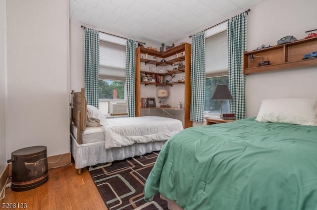 bedroom featuring cooling unit and wood finished floors