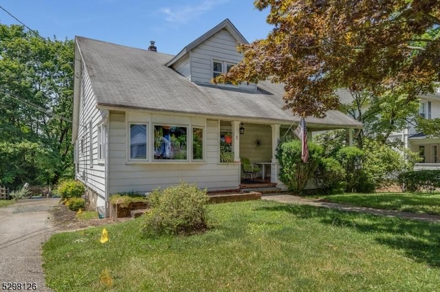 view of front facade featuring covered porch and a front lawn