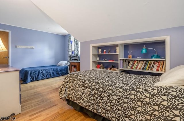 bedroom featuring wood finished floors and vaulted ceiling