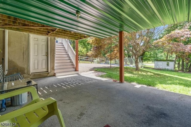 view of patio featuring a storage unit, an outdoor structure, and stairway