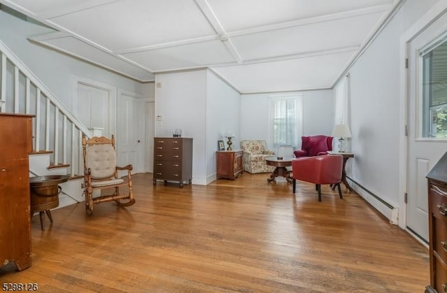 sitting room featuring stairway, coffered ceiling, light wood-type flooring, and a baseboard radiator