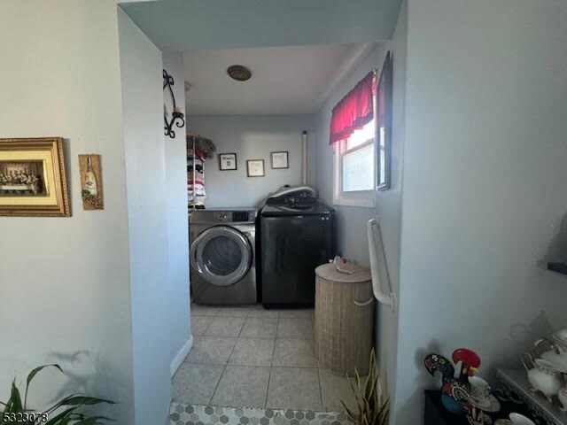 washroom with washer and clothes dryer and light tile patterned floors