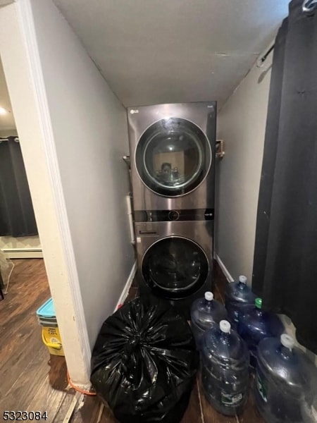 laundry room featuring stacked washing maching and dryer and hardwood / wood-style flooring