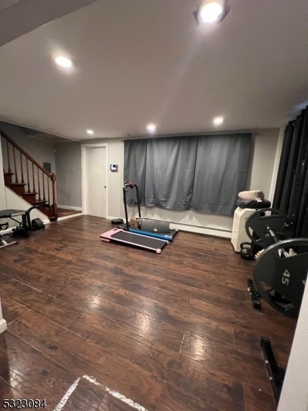 workout area featuring dark hardwood / wood-style floors and baseboard heating