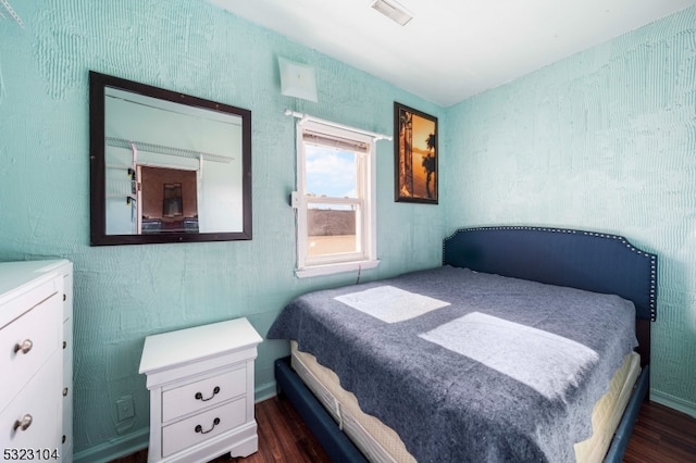 bedroom with dark hardwood / wood-style flooring