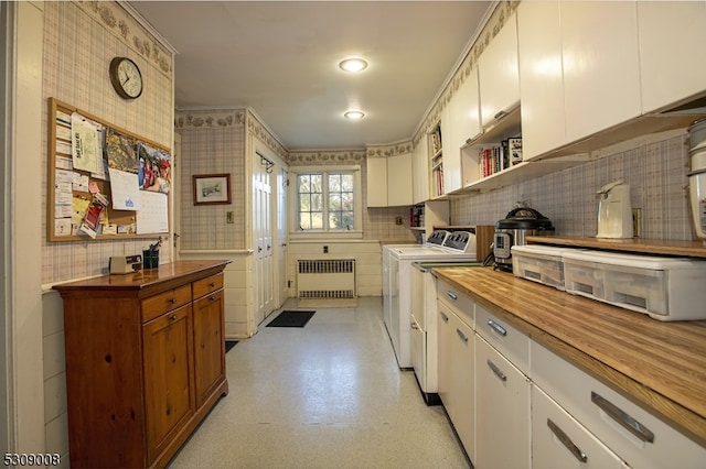 kitchen with butcher block counters, white cabinetry, radiator heating unit, and washer and clothes dryer