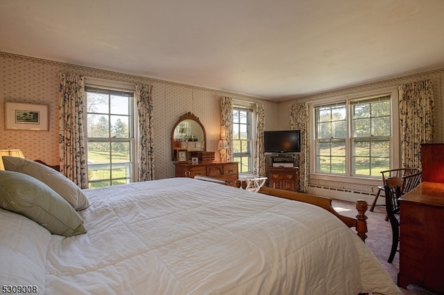 bedroom with carpet, crown molding, and a baseboard heating unit