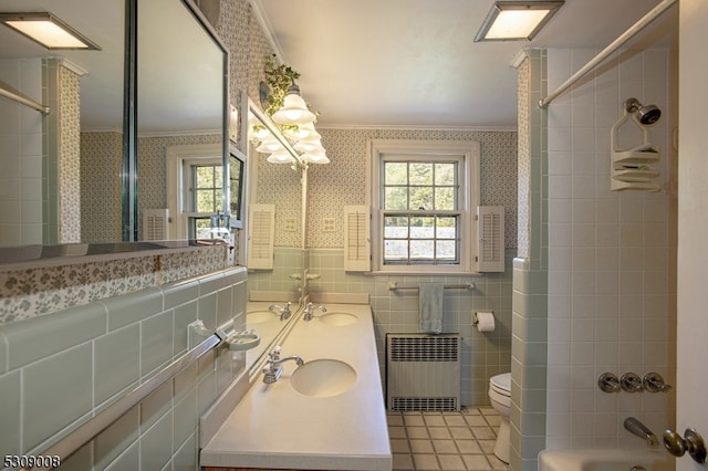 full bathroom with tile walls, radiator heating unit, a healthy amount of sunlight, and crown molding