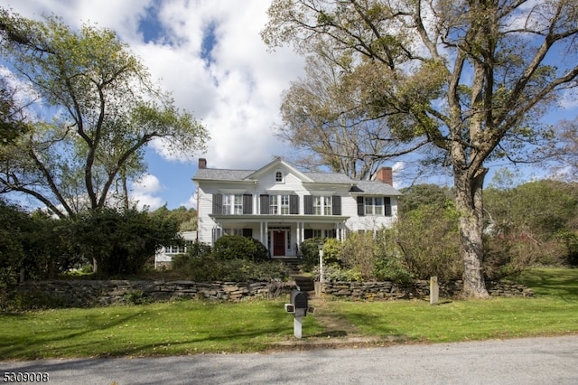 view of front facade with covered porch and a front lawn