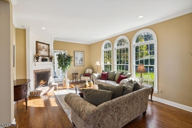 living room featuring recessed lighting, a fireplace, baseboards, dark wood finished floors, and crown molding