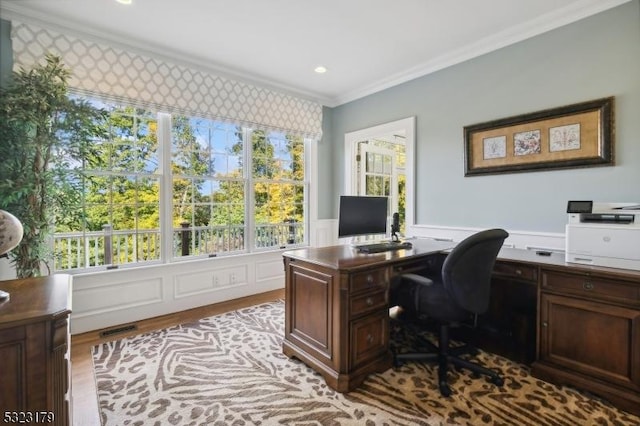 home office featuring plenty of natural light, wainscoting, crown molding, and visible vents