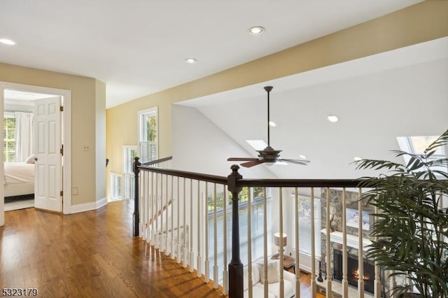 hall featuring baseboards, wood finished floors, and recessed lighting