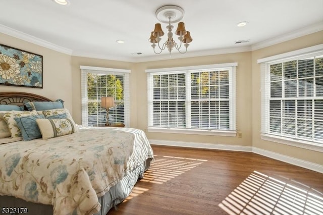 bedroom featuring ornamental molding, wood finished floors, visible vents, and baseboards