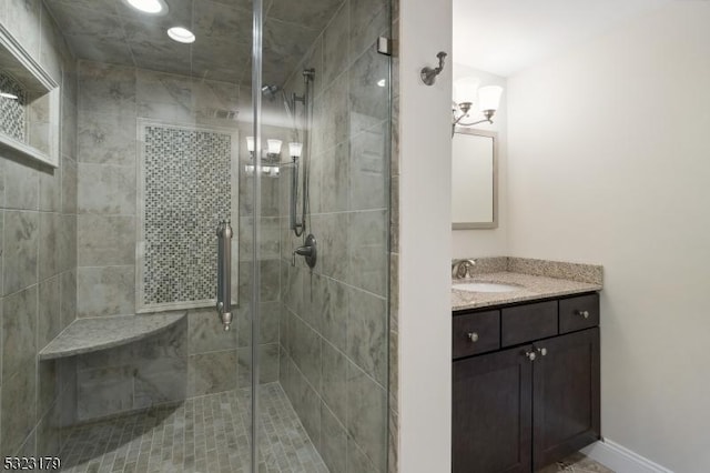 bathroom featuring a shower stall, baseboards, and vanity