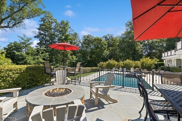 view of patio / terrace with a fenced in pool and a fire pit