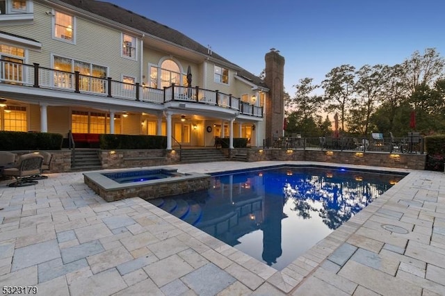 view of pool with a patio area and a pool with connected hot tub