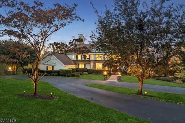 view of front of house with driveway and a front lawn