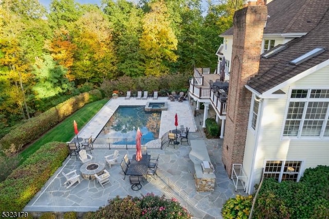 view of pool featuring an outdoor fire pit, a pool with connected hot tub, and a patio