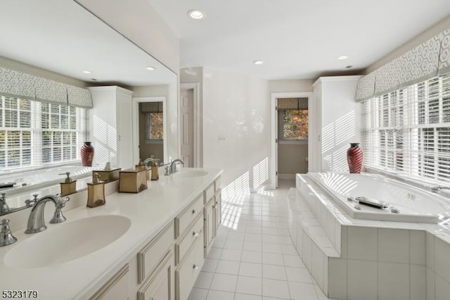 full bath featuring double vanity, a sink, a bath, and tile patterned floors