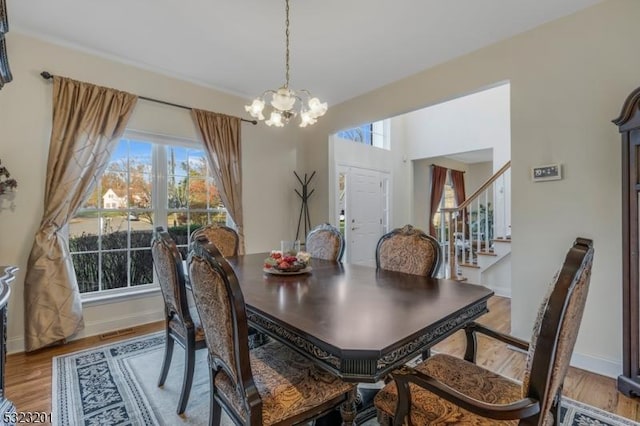 dining space featuring hardwood / wood-style floors and an inviting chandelier