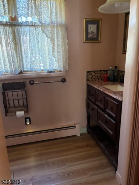 bathroom featuring baseboard heating, vanity, and hardwood / wood-style flooring