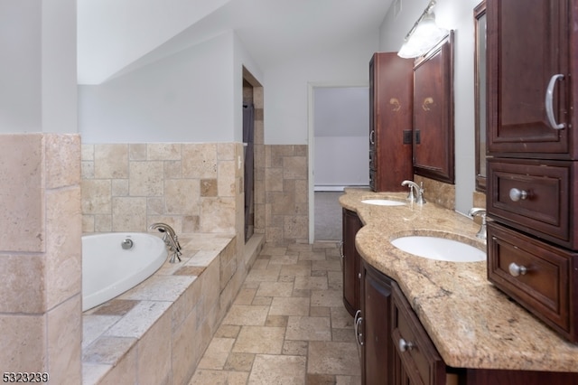 bathroom featuring vanity and tiled tub