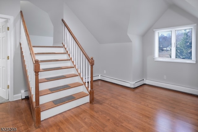 stairs with lofted ceiling, wood-type flooring, and baseboard heating