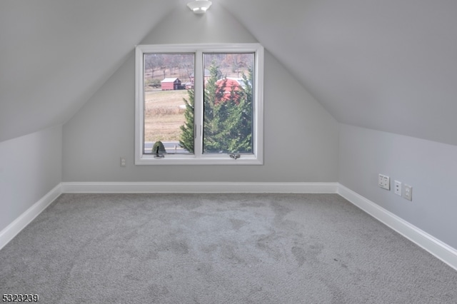 bonus room with vaulted ceiling and carpet floors