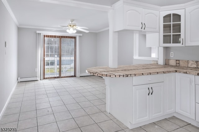 kitchen featuring white cabinets, ceiling fan, a baseboard heating unit, and ornamental molding