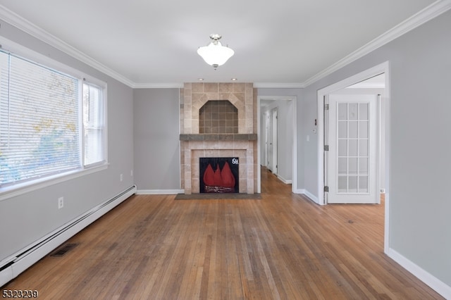 unfurnished living room with baseboard heating, a tiled fireplace, wood-type flooring, and crown molding