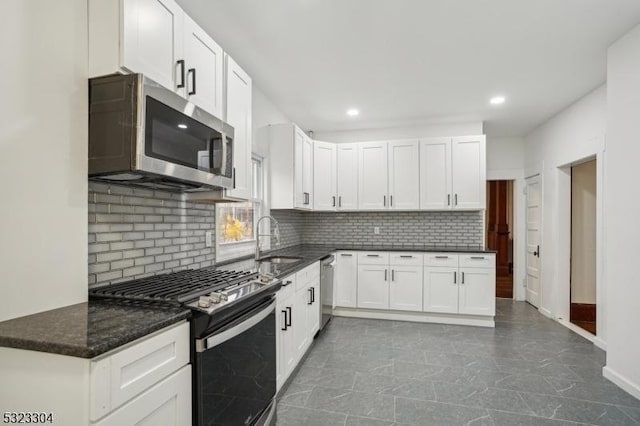 kitchen featuring recessed lighting, backsplash, appliances with stainless steel finishes, white cabinetry, and a sink