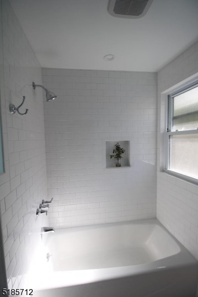 bathroom featuring tiled shower / bath