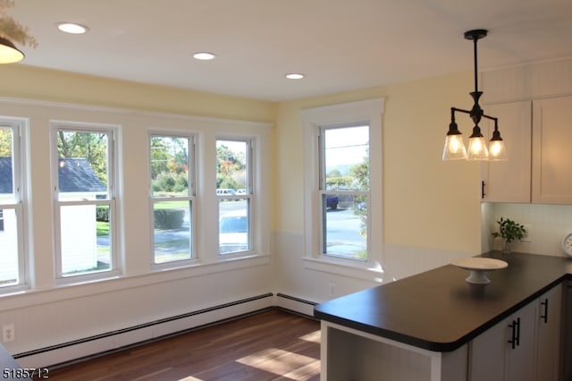 kitchen featuring decorative light fixtures, dark hardwood / wood-style floors, a baseboard radiator, white cabinets, and kitchen peninsula