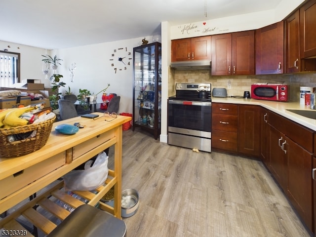 kitchen with decorative backsplash, light wood-type flooring, and stainless steel range