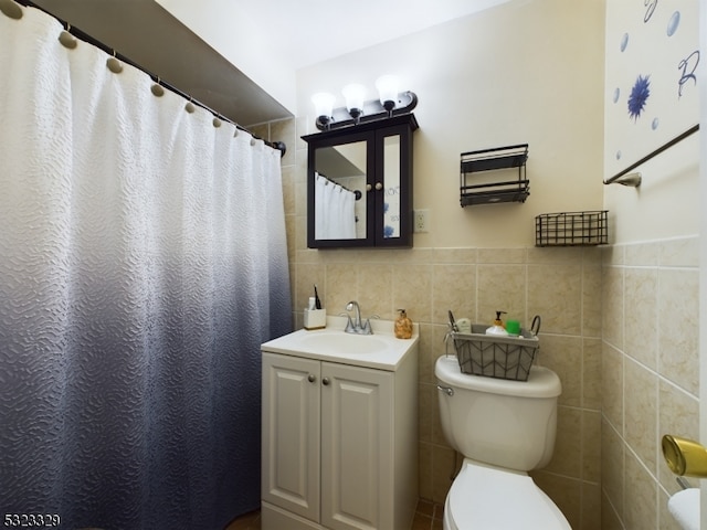 bathroom featuring toilet, vanity, tile walls, and walk in shower