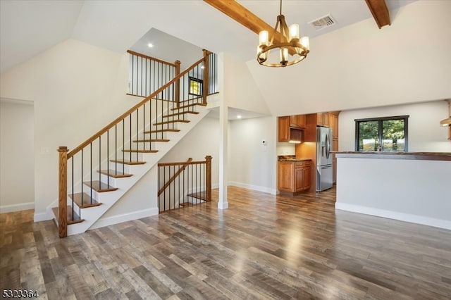 unfurnished living room with dark wood-type flooring, a chandelier, beam ceiling, and high vaulted ceiling