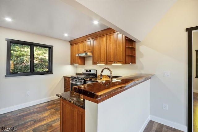 kitchen with gas stove, dark hardwood / wood-style flooring, kitchen peninsula, and dark stone countertops