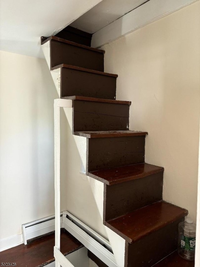 stairway featuring hardwood / wood-style floors and a baseboard radiator