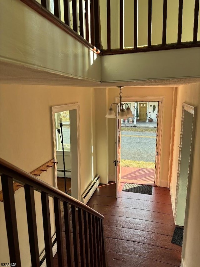 entryway featuring a notable chandelier, dark wood-type flooring, and a baseboard heating unit