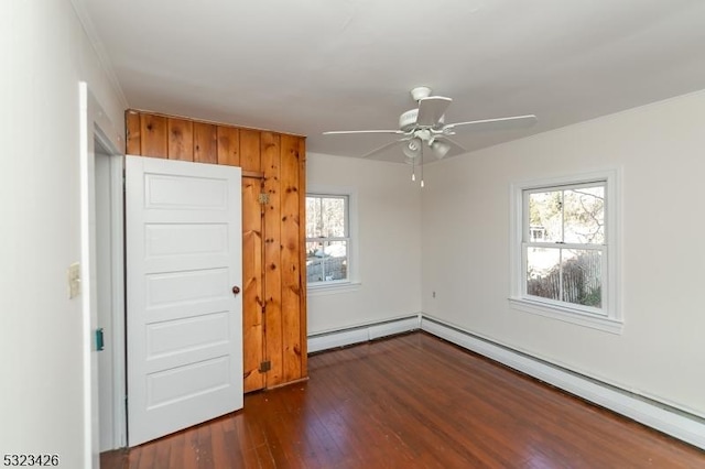 unfurnished bedroom with dark hardwood / wood-style floors, ceiling fan, and a baseboard heating unit