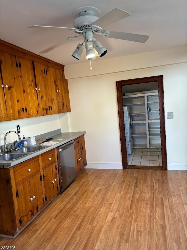 kitchen with ceiling fan, sink, stainless steel dishwasher, and light hardwood / wood-style floors