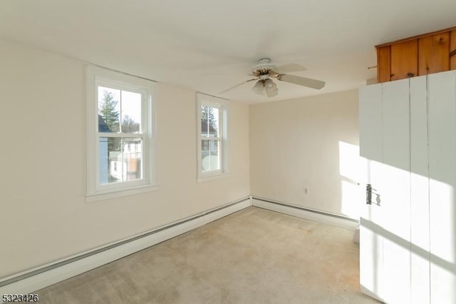 carpeted spare room featuring ceiling fan and a baseboard heating unit