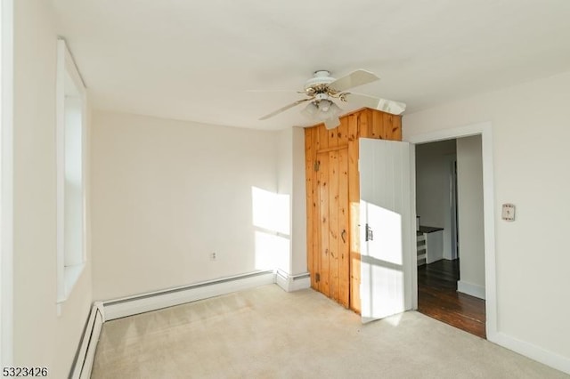 empty room with light carpet, ceiling fan, and a baseboard radiator