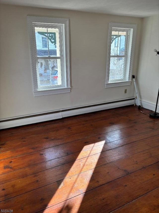 unfurnished room with a baseboard radiator and dark wood-type flooring